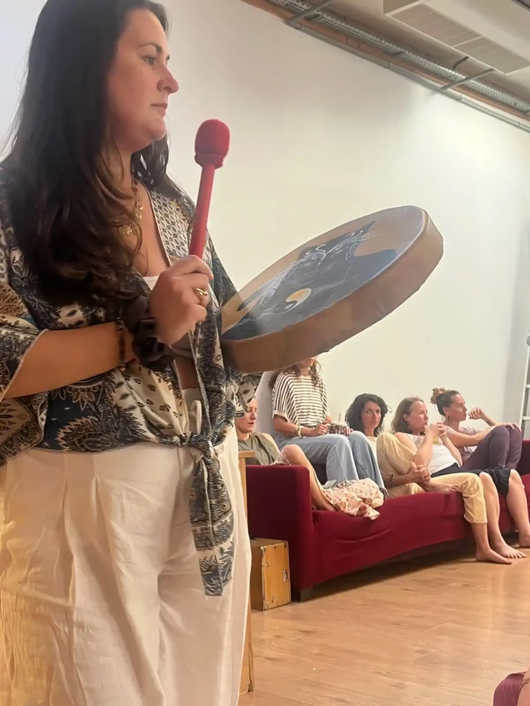 Alicia Dallery jouant du tambour lors d’un atelier de soins énergétiques