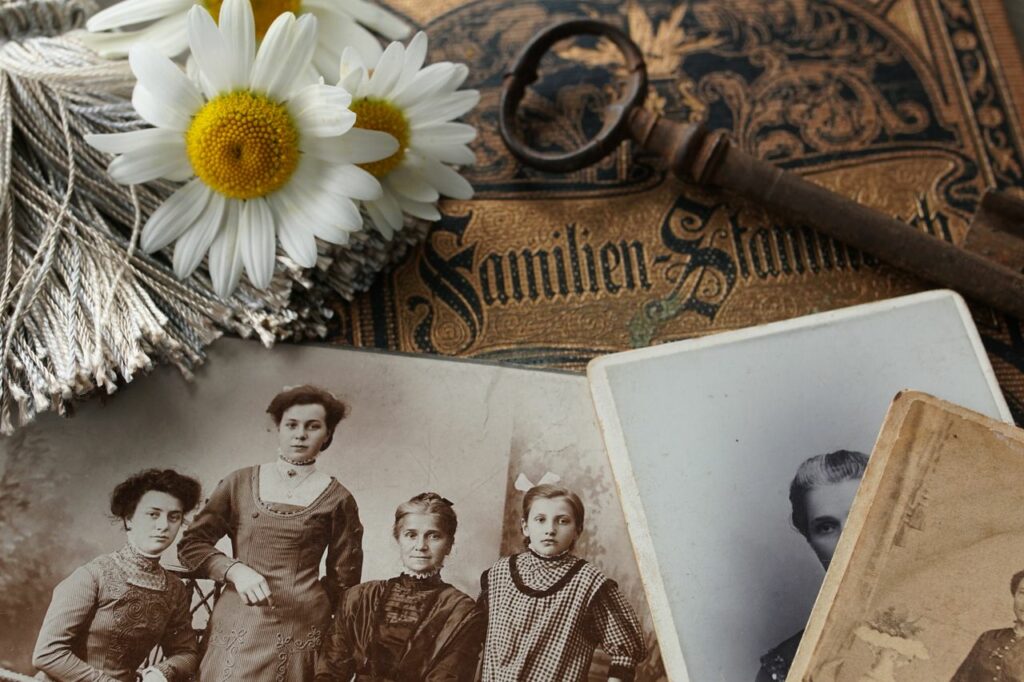 Vieilles photos de famille et livre ancien évoquant l'héritage transgénérationnel en psychogénéalogie et constellations familiales