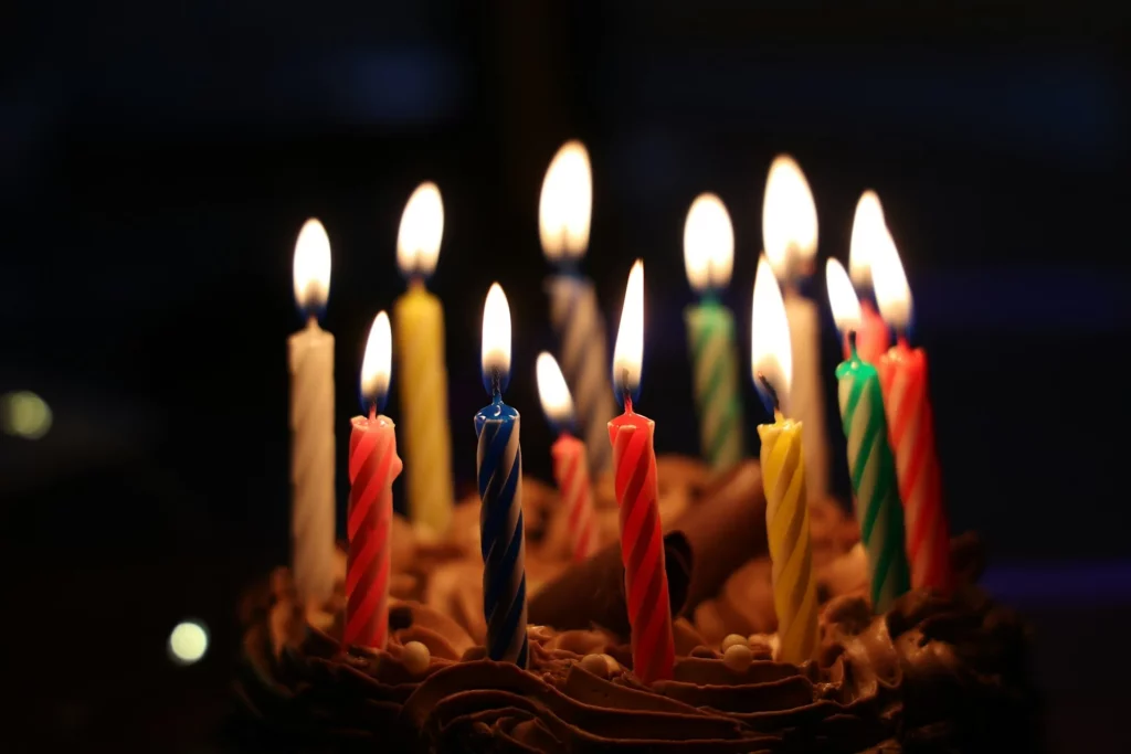Bougies d'anniversaire allumées sur un gâteau, symbole des dates qui se répètent d'une génération à l'autre